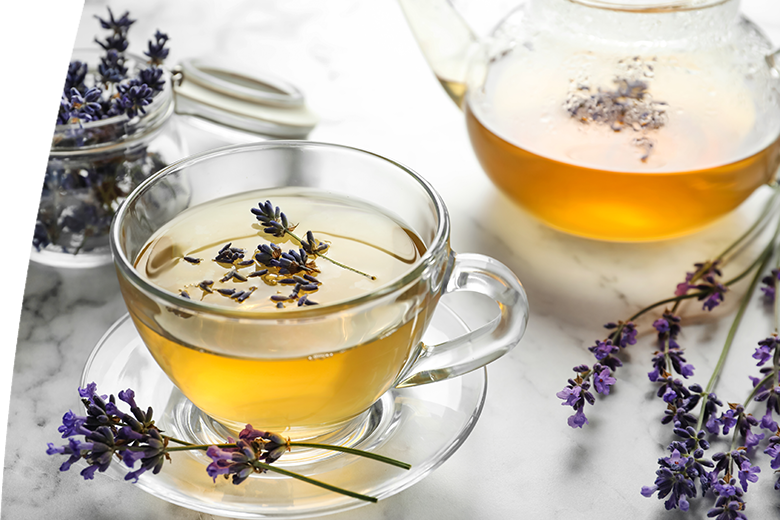 Fresh delicious tea with lavender and beautiful flowers on white marble table
